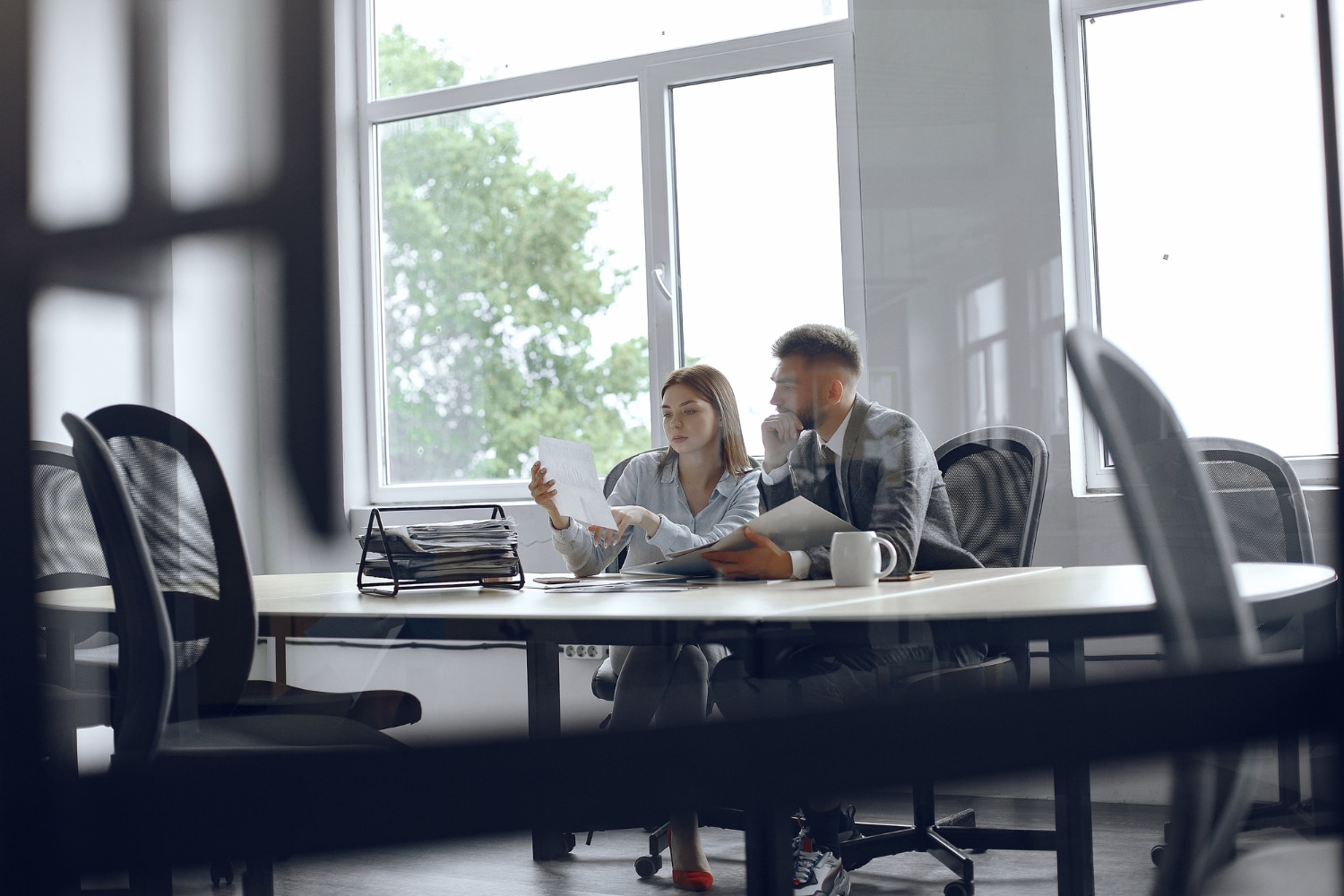 Two colleagues reviewing tender documents at a meeting table